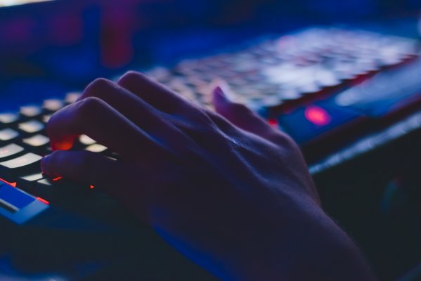 hands on a keyboard that is backlit